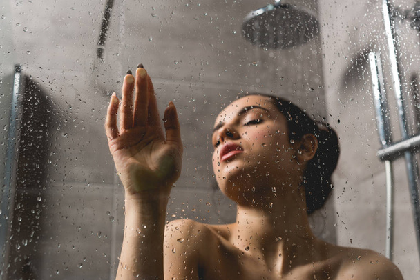 selective focus of attractive and naked woman taking shower in cabin  - Photo, Image