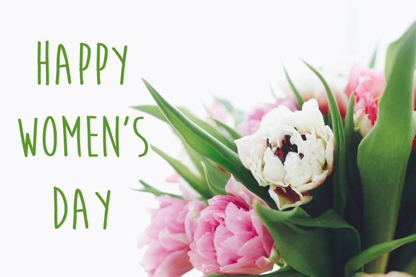 Happy Women's Day signe texte sur de belles tulipes pivoines doubles roses et violettes dans la lumière. Journée internationale de la femme. Carte de vœux florale élégante. 8 mars
 - Photo, image