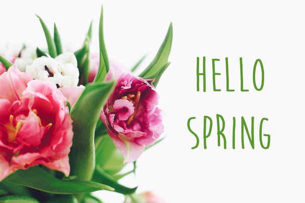 Hola cartel de texto de primavera en hermoso ramo de tulipanes de doble peonía en luz. Primavera. Elegante tarjeta de felicitación floral. Hola marzo.
 - Foto, imagen