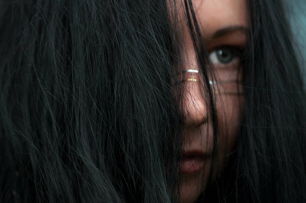 Close up shot of female face covered with black long hair - Fotografie, Obrázek