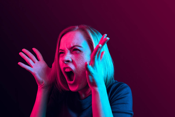 The young emotional angry woman screaming on neon studio background - Φωτογραφία, εικόνα