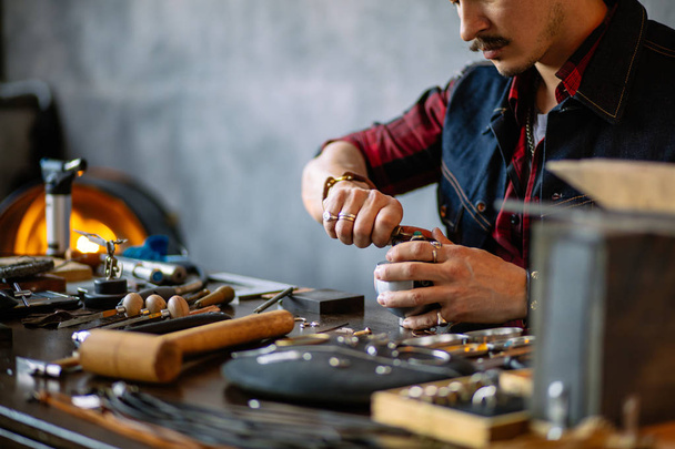 young ambitious craftsman fixing a jewel - Foto, Bild