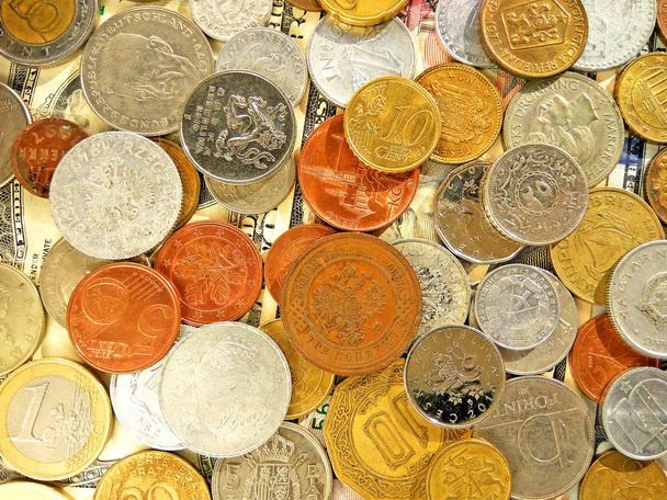 Close up top view image of large amount of old money coins of different countries and times on dollars usa background - Photo, Image