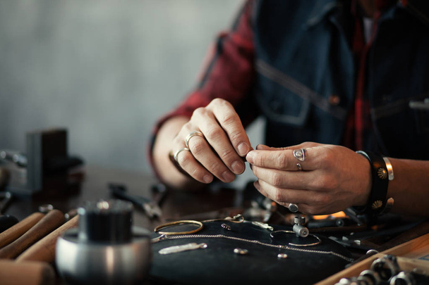 jeweler smoothing rough parts of pieces of jeweller - Photo, image