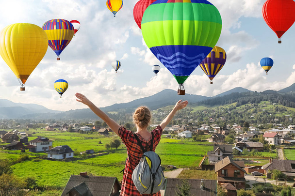 Woman enjoying beautiful view of flying air balloons  - Photo, image