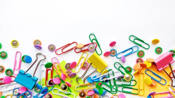 Colorful stationary, back to school, office, business and education concept. School and office supplies paper clips, pins, notes, stickers on white background, flatlay. Mock up. Top view, close up. - Fotografie, Obrázek