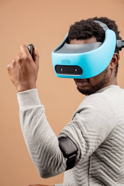 Black man wearing 3d vr glasses, playing videogame, holding joystick in hands - Foto, immagini