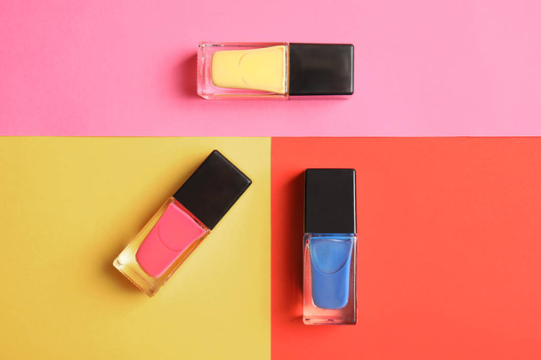 Bottles of nail polish on color background, top view - Foto, imagen