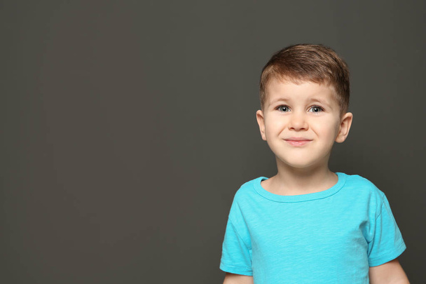 Portrait of cute little boy on dark background. Space for text - Photo, image