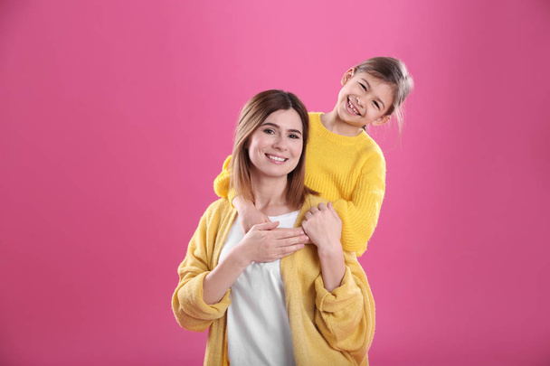 Happy woman and daughter in stylish clothes on color background - Foto, immagini