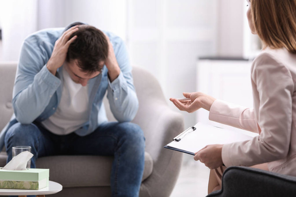 Psychotherapist working with young man in office - Valokuva, kuva