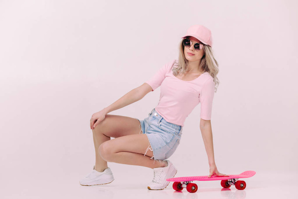 beautiful woman in white t-shirt with pink skateboard - Foto, Imagen