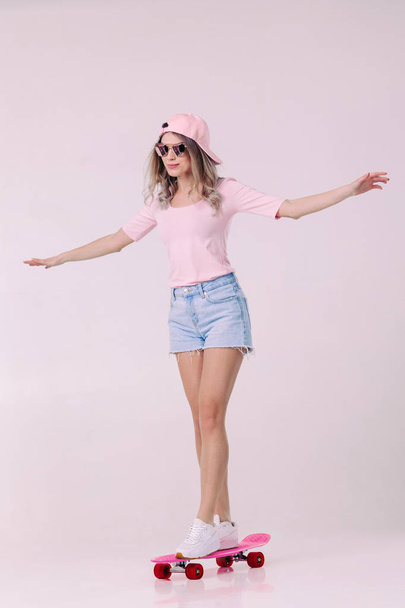 beautiful woman in white t-shirt with pink skateboard - 写真・画像