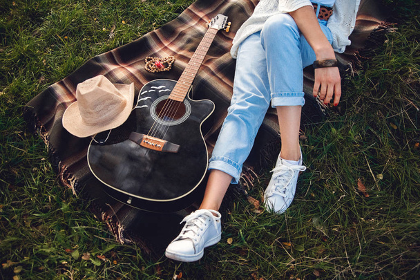 Overhead view of beautiful woman with guitar resting on green lawn. Top view - Fotó, kép