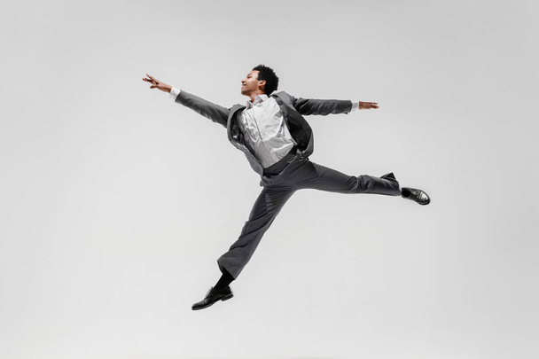 Happy businessman dancing isolated on gray studio background - Fotografie, Obrázek