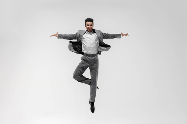 Happy businessman dancing isolated on gray studio background - Photo, Image