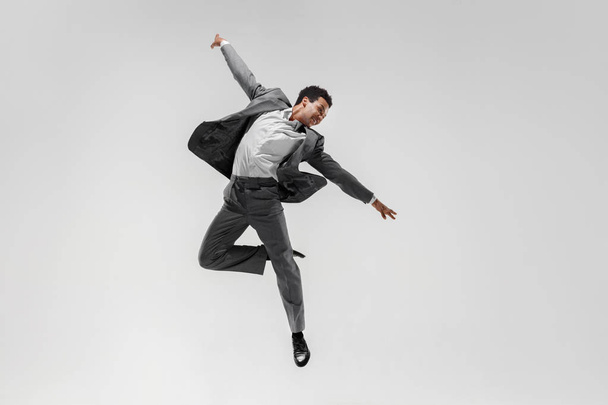 Happy businessman dancing isolated on gray studio background - Fotoğraf, Görsel
