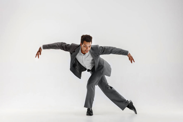 Happy businessman dancing isolated on gray studio background - Foto, Imagem
