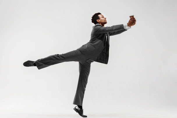 Happy businessman dancing isolated on gray studio background - Фото, зображення
