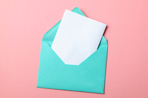 grüner Umschlag und leerer Brief auf rosa Hintergrund - Foto, Bild