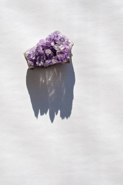 Ancient colorful healing crystals or gemstones on a white background: Amethyst Point and cluster are used to bring positive energy and also inner peace by opening chakras - Photo, Image