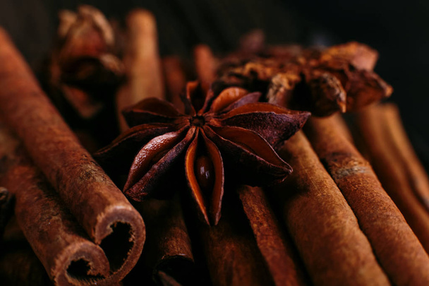 Spices sticks cinnamon and star anise on old table. Rustic dark background, aroma close-up, macro. - Photo, Image