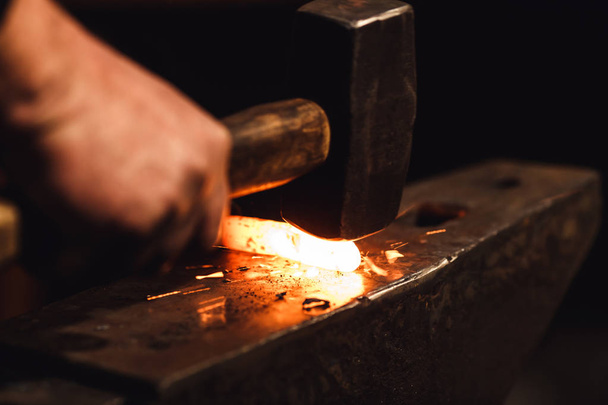 Kovář ruční kování rozžhavený kov na kovadlinu v kovárně s jiskrou ohňostroj. - Fotografie, Obrázek