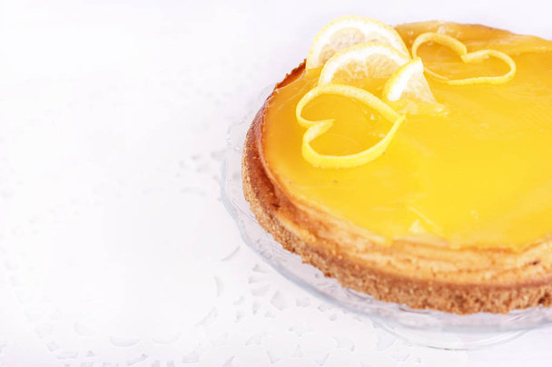 Tarta de queso limón sobre un fondo blanco decorado con ralladura de limón de cerca
 - Foto, Imagen
