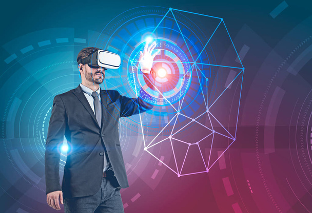 Businessman in dark suit and vr glasses working with biometric verification and face recognition interface with hud over blue red background. Toned image double exposure - Fotó, kép