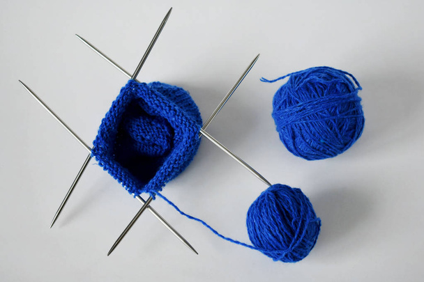 A piece of knitting with ball of yarn and a knitting needles - Foto, Imagem