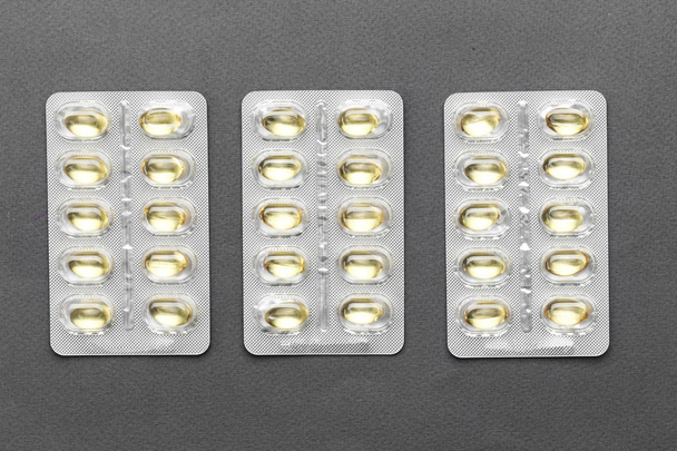 pills in a blister without inscriptions on a black background. space for tex - Foto, afbeelding