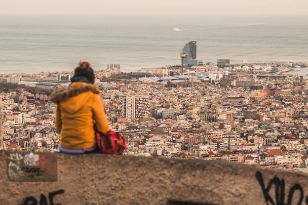 Uma menina está admirando as vistas da cidade de Barcelona. Podemos ver na distância o hotel W, entre outros monumentos pendentes. Ela está nos abrigos antiaéreos de Barcelona
. - Foto, Imagem