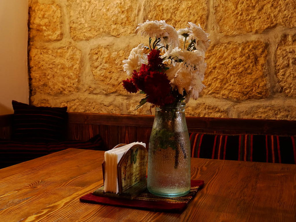 Vase with Flowers on a Table in a Native Bulgarian Restaurant - Fotoğraf, Görsel