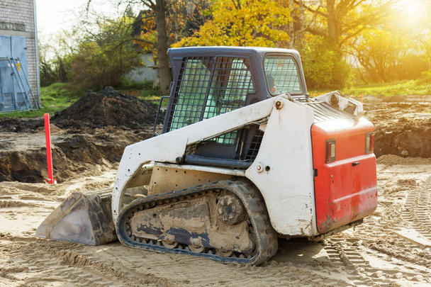 Mini excavator bobcat standing at construction site - Photo, Image