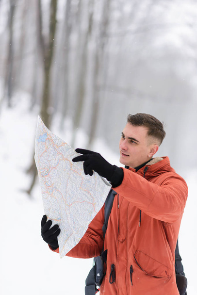 Boy Considers a Map in the Winter Snowy Forest - Fotoğraf, Görsel