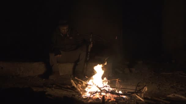 Ugly Dangerous zombie monster Sitting near the bonfire with heavy Cross bow in Dark ruined concrete shelter. Horror Character concept, Armed and grasepainted entity - Footage, Video