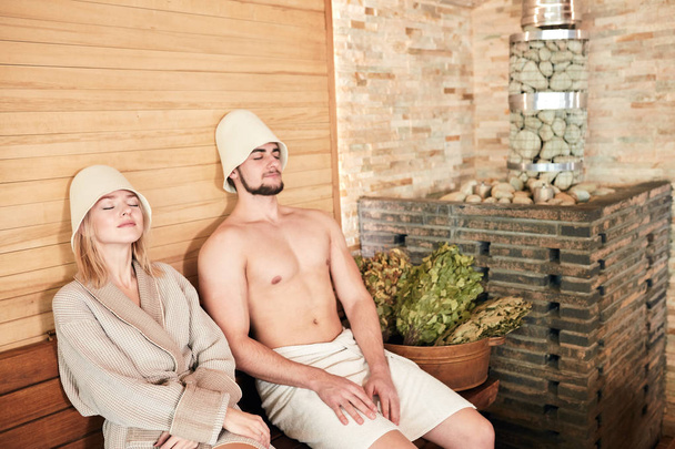 Beautiful couple relaxing in sauna and caring about health and skin - Foto, Imagem
