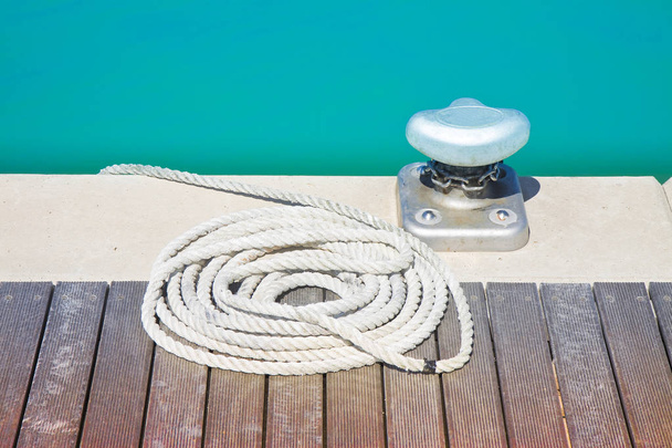 Limpiador para amarre de embarcaciones en plataforma de madera
 - Foto, Imagen