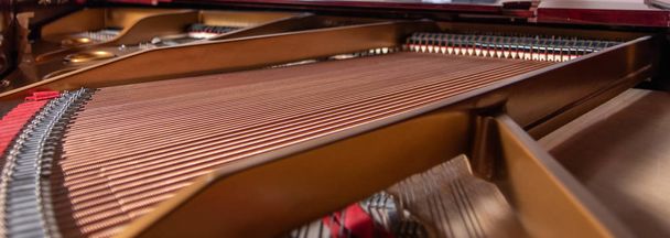 the interior of a grand piano showing the harp and its strings - Photo, Image