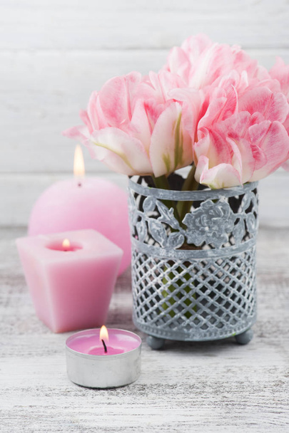 Λουλούδια φρέσκα ροζ τουλίπα και αναμμένα κεριά σε φόντο ξύλινη rustik - Φωτογραφία, εικόνα
