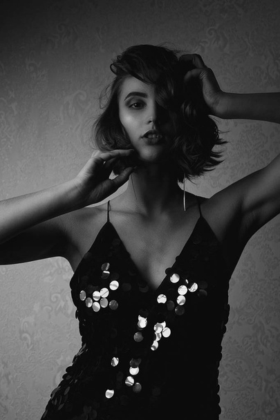 Black and white portrait of beautiful brunette girl wearing sparkling dress - Zdjęcie, obraz