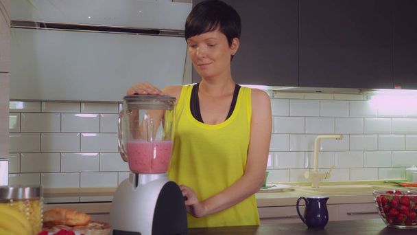 Girl makes juice with berries in apartment. - Photo, Image