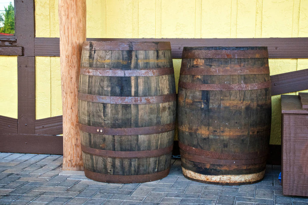 2 つの古いアンティーク木製ウイスキー樽かワイン樽は壁の外にあります。. - 写真・画像