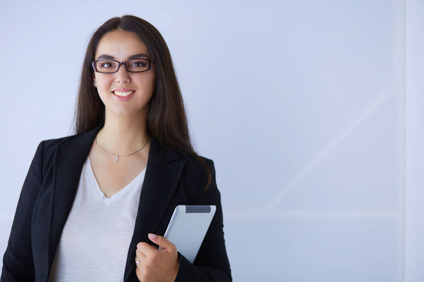 Portrait of smiling young business woman with digital tablet in her hands. - Φωτογραφία, εικόνα