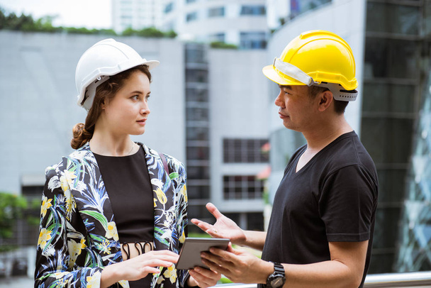Beautifule woman engineer discussing with worker - Photo, Image