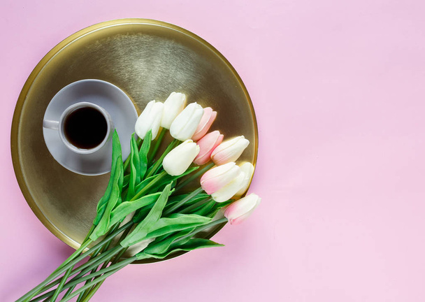 Zlatý talíř s makaroony, tulipány, šálek kávy na růžovém pozadí. Zavři to. Dekorace pro matky den, den mezinárodních žen, sváteční zázemí. - Fotografie, Obrázek