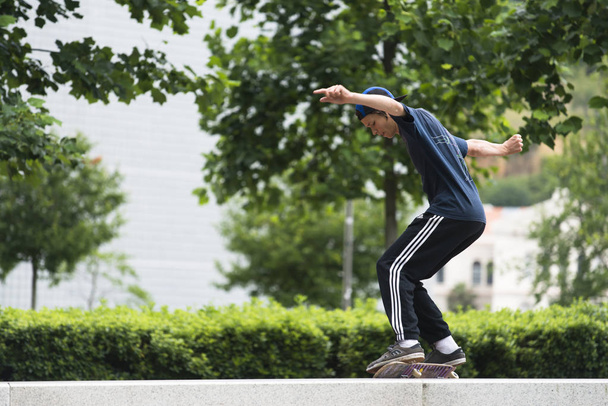 boy riding on skateboard at city street - Фото, зображення