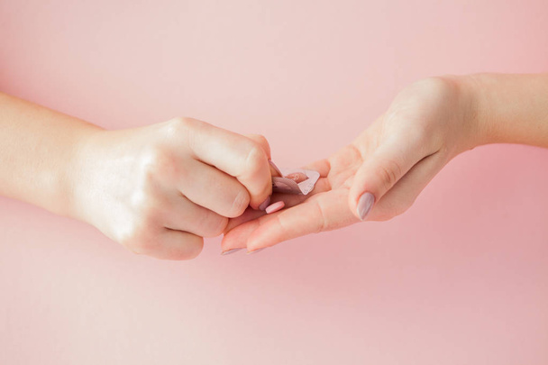 Pink pills tablets in the woman hand on pink background. Top view. Flat lay. Copy space. Medicine concept. - Zdjęcie, obraz