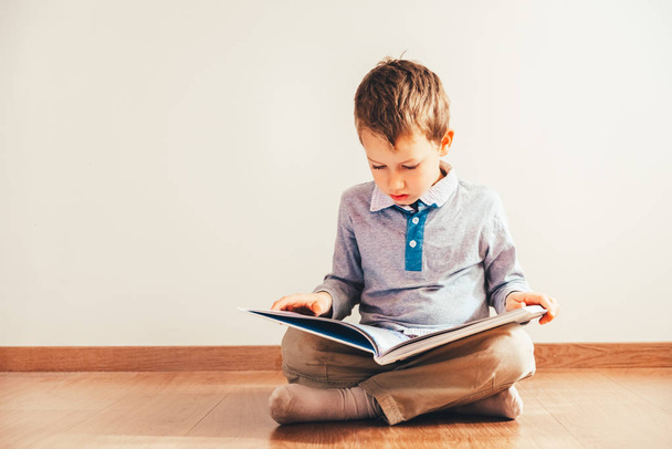 Portrait of boy interested in reading a book. - Zdjęcie, obraz