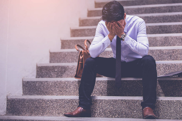 uomo d'affari stressato con mal di testa seduto alle scale. deluso per la ricerca di lavoro
 - Foto, immagini